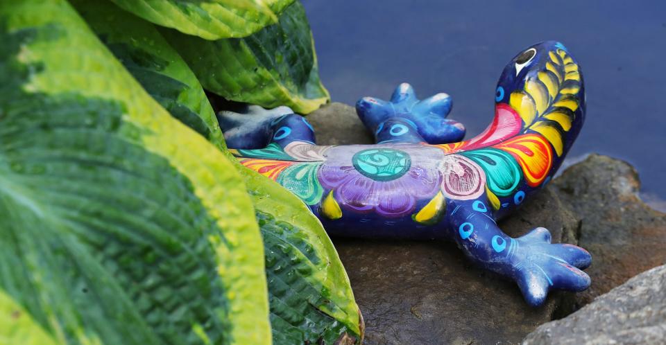 A colorful lizard statue pokes out of the flower bed at Joseph and Barb Jurcak's garden during the 76th annual Hudson Garden Club Home and Garden Tour Saturday.