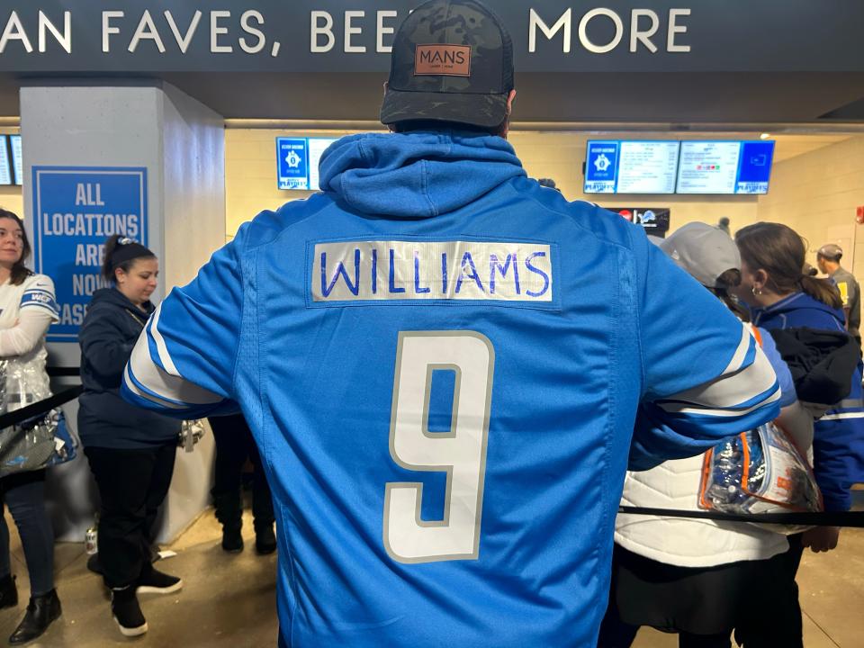 Chris Waisen, 32, of Durand, covers up his Lions’ Matthew Stafford jersey with duct tape and writes “Williams” on his back for the playoff game Sunday, January 14, 2024. Lions’ wide receiver Jameson Williams wears the team’s No. 9 jersey.