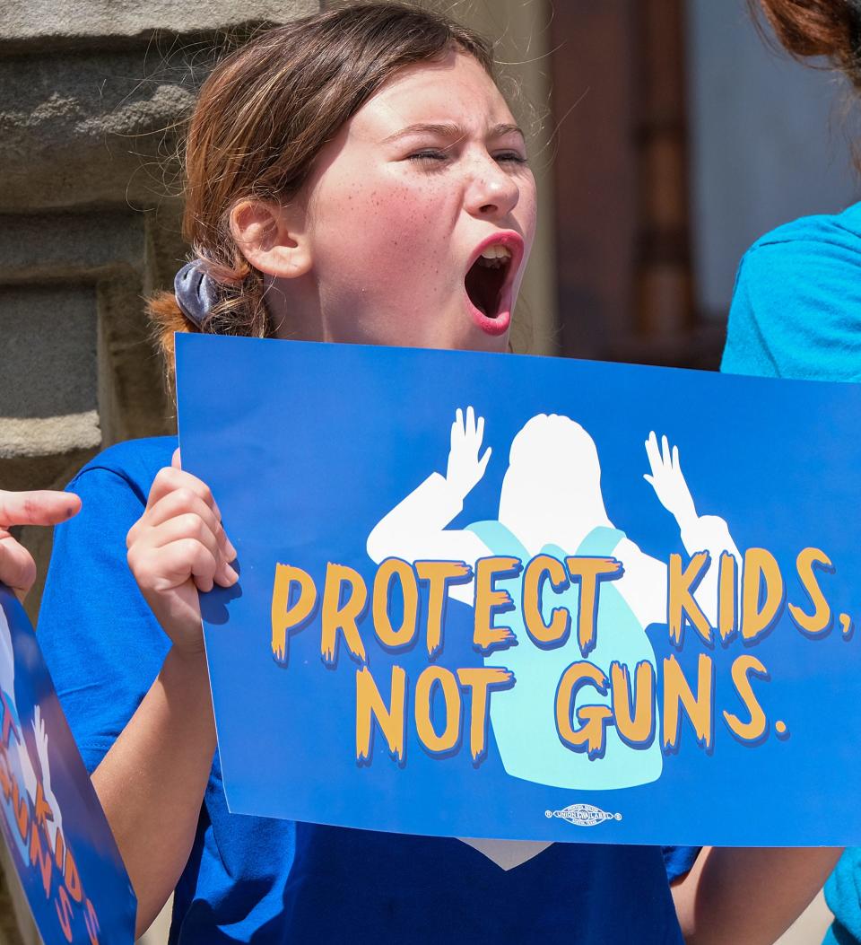 Riley P, 10, from Milan, holds up a sign on the steps of the Capitol in Lansing at the March for Our Lives rally Saturday, June 11, 2022.
