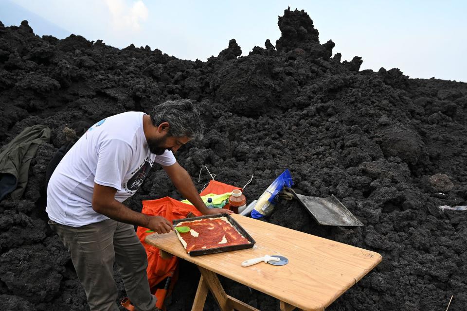 David Garcia prepares a pizza to cook on the lava rivers in Guatemala,