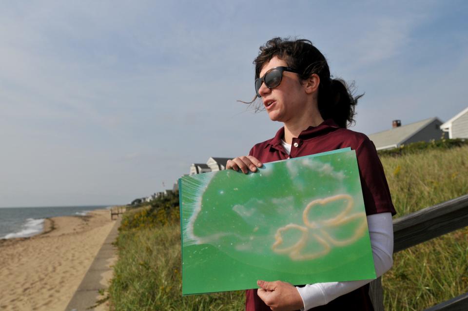 Environmental researcher Nicole Corbett holds a photo on Sept. 28 in Mashpee of a moon jellyfish she took with her underwater camera. Corbett has been studying seaweed and jellyfish to get an understanding of the water quality in Cape Cod embayments and estuaries, especially Popponesset Bay.