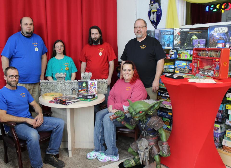 Our House Games staff, Nick West of Monroe (seated, left) Drew Taulbee III of Newport, Jaden Coss of Adrian, Michael Layton of Monroe, and LaSalle residents Kristian (Kris) Bezeau and Erika Branstetter (seated, right) sell and rent games that are played around the table with family and friends.