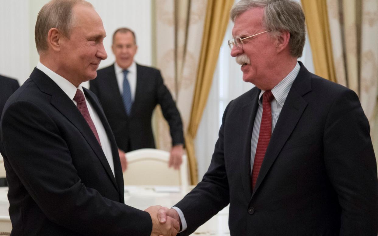 Donald Trump's national security adviser John Bolton greets Vladimir Putin in the Kremlin on Wednesday - AP POOL