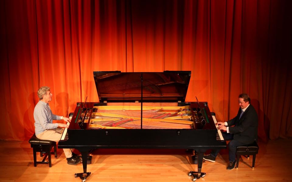 Piano curator Adrian Church (left) and Simon Hill, chief Trustee (right) play a Pleyel duo-clave in the museum's concert hall