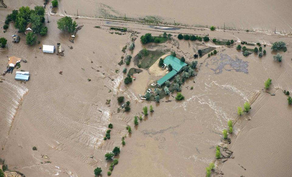 An aerial view shows flood waters surrounding a building structure in Longmont