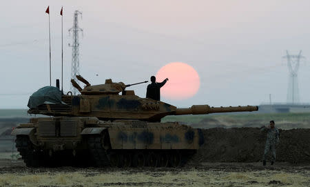 A Turkish soldier points as he stands on a tank during a military exercise near the Turkish-Iraqi border in Silopi, Turkey, September 22, 2017. REUTERS/Umit Bektas