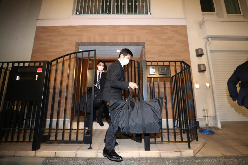 Japanese prosecutors carry bags as they leave the residence of former auto tycoon Carlos Ghosn on January 2, 2020, after Ghosn fled Japan to avoid a trial. - Former Nissan boss Carlos Ghosn, who fled to Lebanon to avoid a Japanese trial, had a second French passport, a source said on January 2, as authorities raided his Tokyo residence as part of a probe into the embarrassing security lapse. (Photo by STR / JIJI PRESS / AFP) / Japan OUT (Photo by STR/JIJI PRESS/AFP via Getty Images)