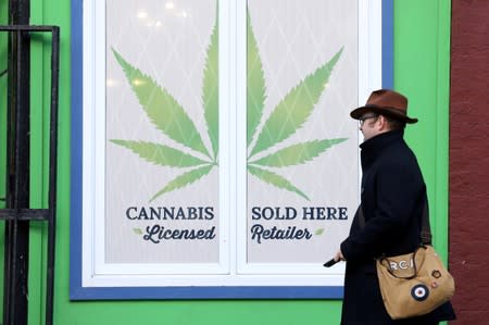 FILE PHOTO: A man walks past a sign outside the Natural Vibe store after legal recreational marijuana went on sale in St John's