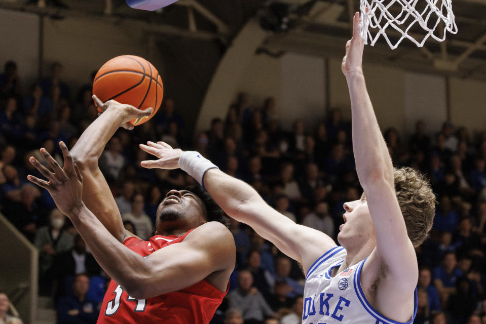 Louisville's Emmanuel Okorafor (34) shoots as Duke's TJ Power defends during the first half of an NCAA college basketball game in Durham, N.C., Wednesday, Feb. 28, 2024. (AP Photo/Ben McKeown)