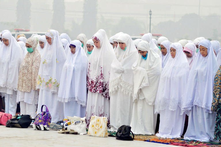 Indonesian Muslim women take part in mass prayers asking for rain at a square covered by thick haze in Dumai on June 25, 2013. Indonesian President Susilo Bambang Yudhoyono has apologised to Singapore and Malaysia over fires that have cloaked the countries in thick haze, as thousands of emergency workers were deployed Tuesday to tackle the blazes