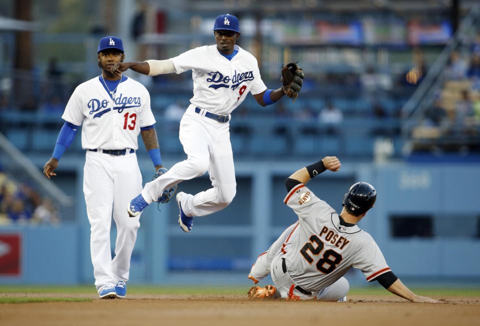 Los Angeles Dodgers second baseman Dee Gordon, center, forces out San Francisco Giants' Buster Posey, right, and throws out Michael Morse out at first base to complete the double play as shortstop Hanley Ramirez, left, stands near during the first inning of a baseball game, Friday, May 9, 2014, in Los Angeles. (AP Photo/Danny Moloshok)