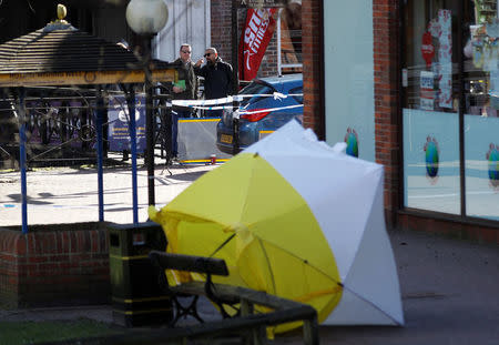 Local officials survey the scene as the forensic tent, covering the bench where Sergei Skripal and his daughter Yulia were found, is blown out of position in the centre of Salisbury, Britain, march 8, 2018. REUTERS/Peter Nicholls