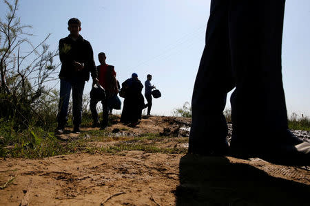 Displaced Iraqis from Mosul walk to cross the Tigris by boat as flooding after days of rainfall has closed the city's bridges, at the village of Thibaniya, south of Mosul, Iraq April 16, 2017. REUTERS/Muhammad Hamed