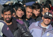 Migrants wait in line to receive supplies from the Red Cross at the Vucijak refugee camp outside Bihac, northwestern Bosnia, Monday, Oct. 21, 2019. Authorities in the town of Bihac on Monday stopped the delivery of water supplies to the Vucjak camp saying they want to draw attention to the problems in the camp set up on a former landfill and near mine fields from the 1992-95 war. (AP Photo/Eldar Emric)