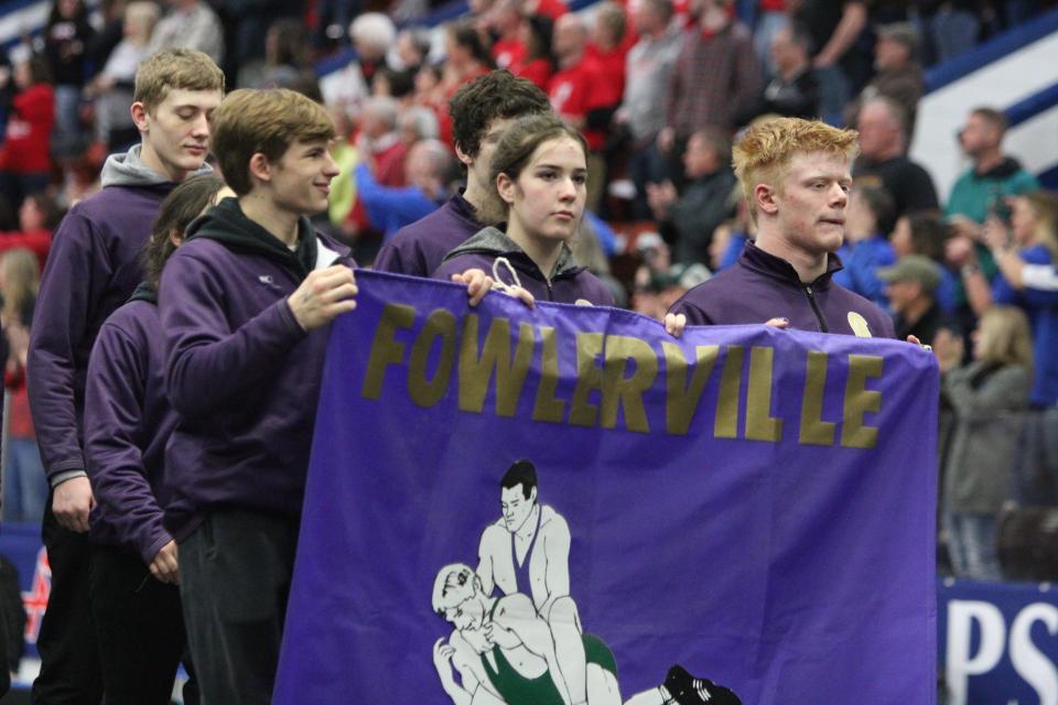 Fowlerville's (from left) Dalton Daniel, Maggie Buurma and Richard Davis carry the team's banner during the entrance before the state Division 2 wrestling quarterfinals Friday, Feb. 24, 2023 at Wings Event Center.