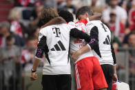 Injured Bayern's Kingsley Coman is assisted to leave the field during the German Bundesliga soccer match between Bayern Munich and Cologne at the Allianz Arena in Munich, Germany, Saturday, April 13, 2024. (AP Photo/Matthias Schrader)