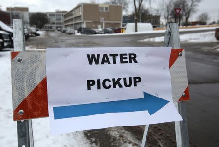 A "Water Pickup" sign points to a bottled water distribution center for Flint residents at a fire station in Flint, Michigan January 13, 2016. Michigan Governor Rick Snyder said February 5, 2016 he wants officials to focus on solving problems around lead-contaminated drinking water in flint instead of laying blame as he said some have been doing. REUTERS/Rebecca Cook/Files