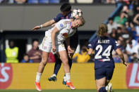 Lyon's Lindsey Horan jumps for the ball with PSG's Elisa De Almeida, in the background, during the women's Champions League semifinal, second leg, soccer match between Paris Saint-Germain and Olympique Lyonnais at Parc des Princes, in Paris, Sunday, April 28, 2024. (AP Photo/Thibault Camus)