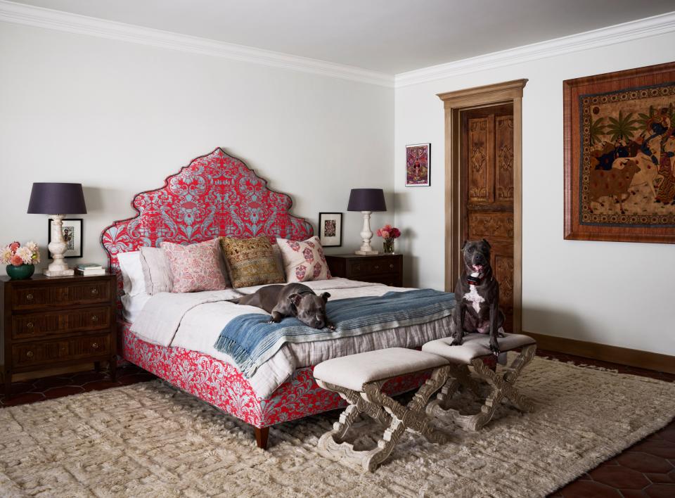 The couple’s rescued pit bulls, Poe and Diamond, make themselves comfortable in the main bedroom, where the bed is upholstered in a vivid Fortuny fabric.