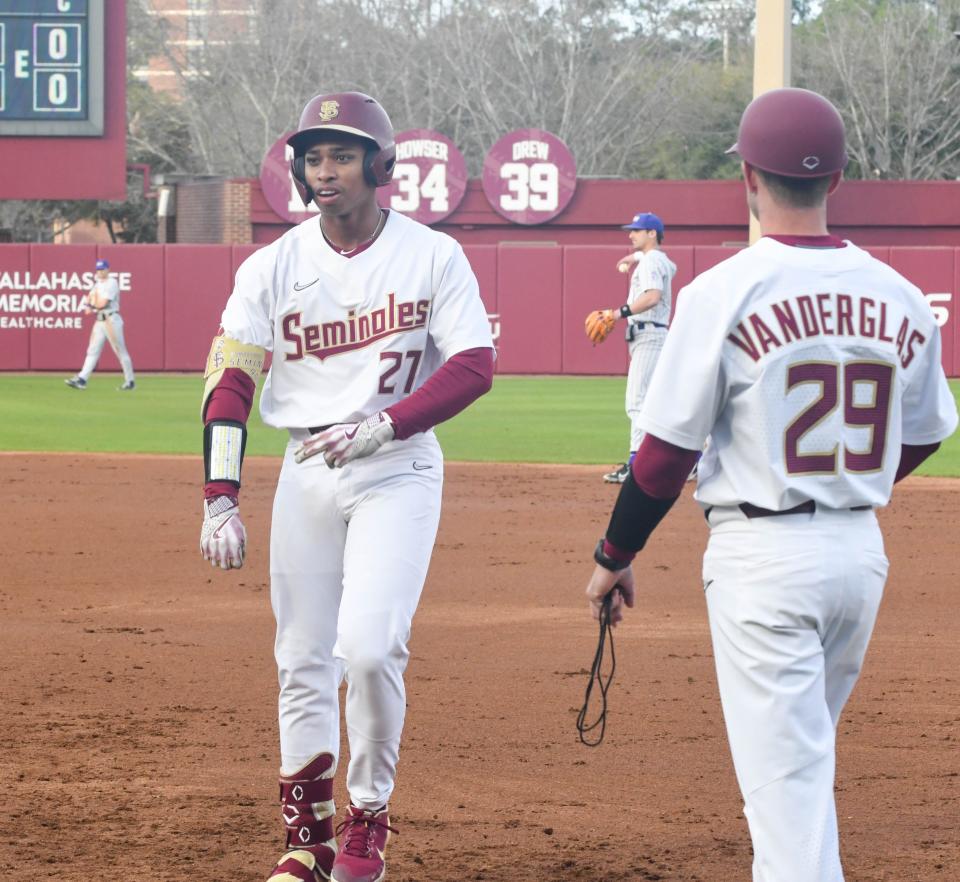 Florida State freshman DeAmez Ross (left) celebrates his first career hit during the first inning of opening day against James Madison on Feb. 17, 2023, at Dick Howser Stadium.