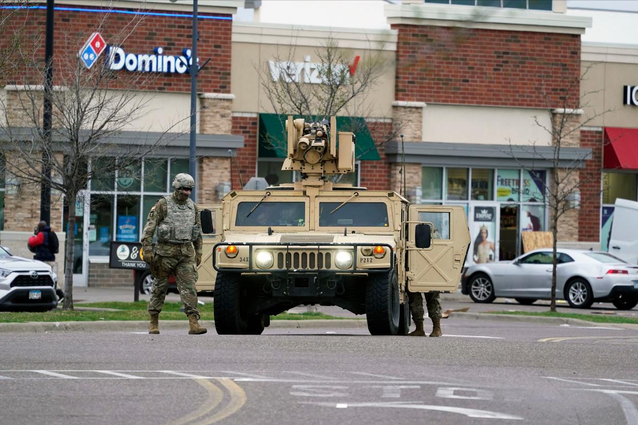 A National Guard soldier maintains watch and directs traffic at a shopping center in Brooklyn Center, Minn., a suburb of Minneapolis, Monday, April 12, 2021. A Black man died after being shot by police in a Minneapolis suburb during a traffic stop and crashing his car several blocks away, sparking violent protests that lasted into the early hours Monday as officers in riot gear clashed with demonstrators and the man’s mother called for calm.