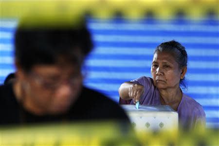 A voter casts her ballot at a polling station in Bangkok during a vote to elect a new Senate March 30, 2014. REUTERS/Damir Sagolj