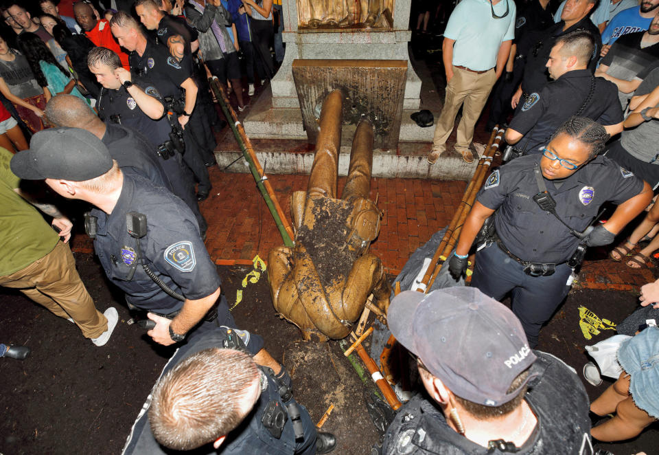 <p>An der University of North Carolina bewachen Polizisten die umgestürzte Statue des Konföderierten „Silent Sam“. Rund 250 Demonstranten hatten auf dem Universitätscampus gegen Rassismus protestiert und das Bürgerkriegsdenkmal beschädigt. (Bild: Reuters/Jonathan Drake) </p>