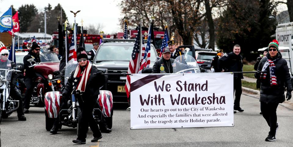 Amy Gollwitzer and Sue Turowski hold a tribute to Waukesha at the beginning of the 41st Grafton Christmas Parade Saturday, Nov. 27, 2021, starting at Sixth Avenue and Washington Street in Grafton, Wis. "They handed us the sign and we both started crying," said Gollwitzer.