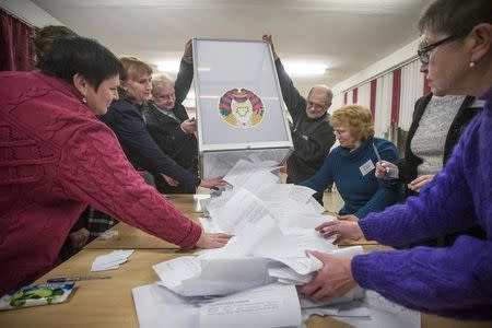 Members of a local electoral commission empty a ballot box at a polling station in Minsk, Belarus, October 11, 2015. REUTERS/Yauhen Yerchak