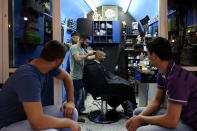 <p>A young Palestinian man gets a haircut in a barber shop while others watch and wait in East Jerusalem. </p>