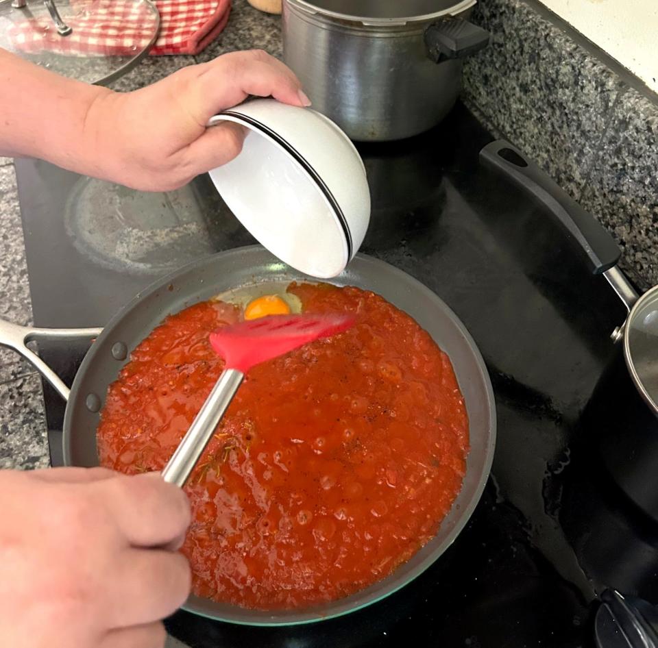 Adding an egg to the pan for Ina Garten's Eggs in Purgatory