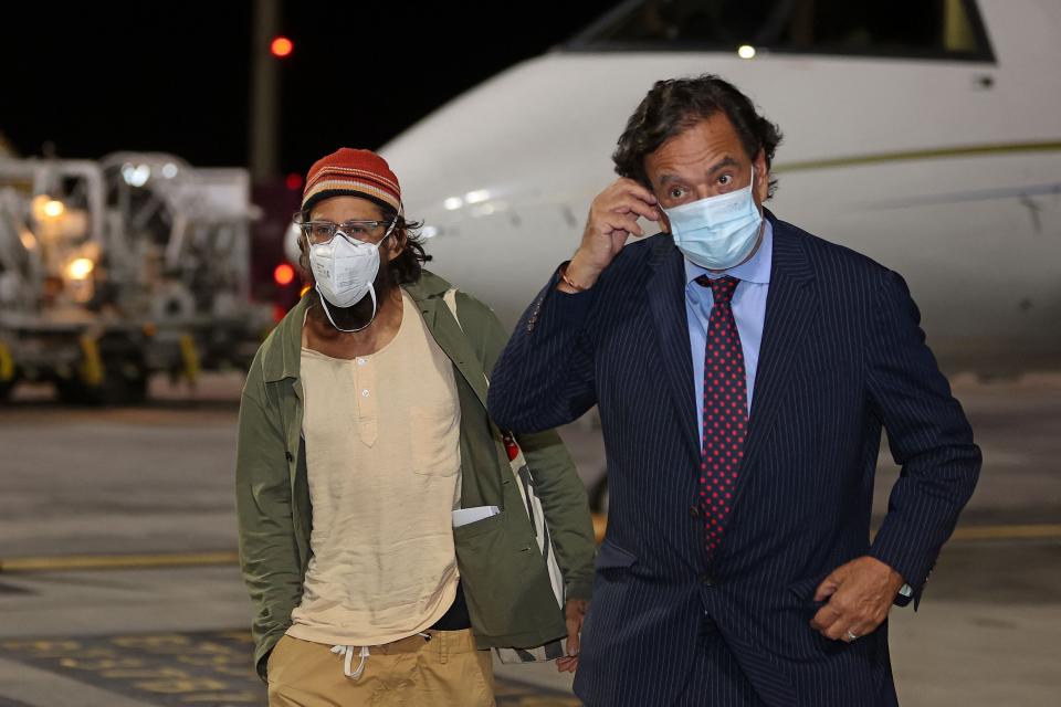 US journalist Danny Fenster (L), who was imprisoned in Myanmar, disembarks from an aircraft alongside former US diplomat Bill Richardson upon their arrival at Hamad International Airport in Qatar's capital Doha on November 15, 2021. - A US journalist imprisoned in Myanmar since May was pardoned and deported, a day before he was due to face terror and sedition charges that could have jailed him for life. The military has squeezed the press since taking power in a February coup, arresting dozens of journalists critical of its crackdown on dissent, which has killed more than 1,200 people according to a local monitoring group.