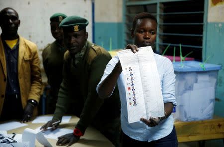 An election official from the Independent Electoral and Boundaries Commission (IEBC) counts ballots after the close of the polling station during the presidential election in Nairobi, Kenya August 8, 2017. REUTERS/Baz Ratner