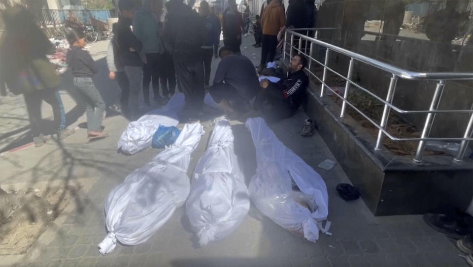 Bodies are wrapped in white shrouds on ground outside Shifa Hospital in Gaza City. Israeli troops fired on a crowd of Palestinians waiting for aid in Gaza City on Thursday, witnesses said. (AP Photo)
