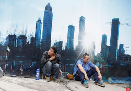 FILE PHOTO - Workers rest outside a construction site in Beijing's central business district, China, July 15, 2016. REUTERS/Jason Lee/File Photo