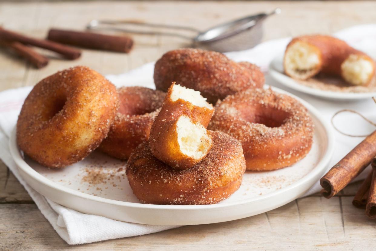 Homemade donuts with sugar and cinnamon on a wooden background. Rustic style, selective focus.