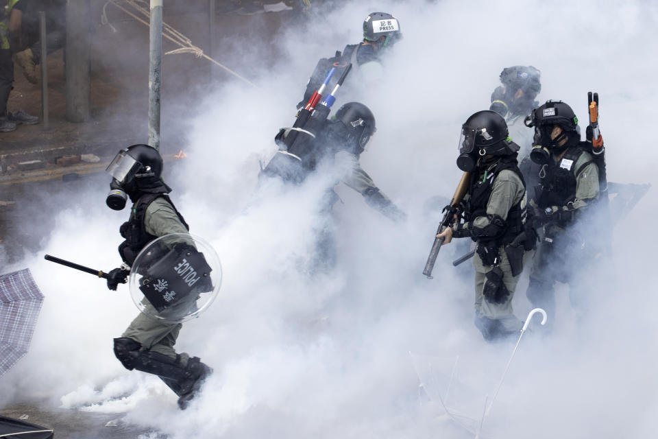 Policías con equipo antimotines avanzan en medio del humo en la Universidad Politécnica de Hong Kong, el lunes 18 de noviembre de 2019. (AP Foto/Ng Han Guan)