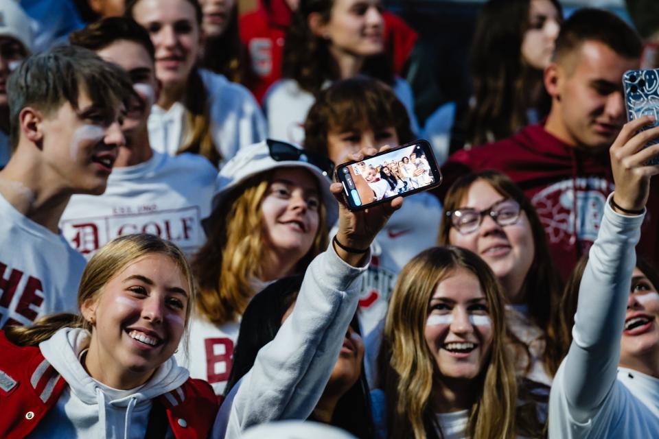 Dover student-fans take selfies during week 10 high school football action against New Phila, Friday, Oct. 20 at the ‘Brick House’ in Dover, Ohio. This was the 120th annual Dover-Phila rivalry game, which was first played in 1896.