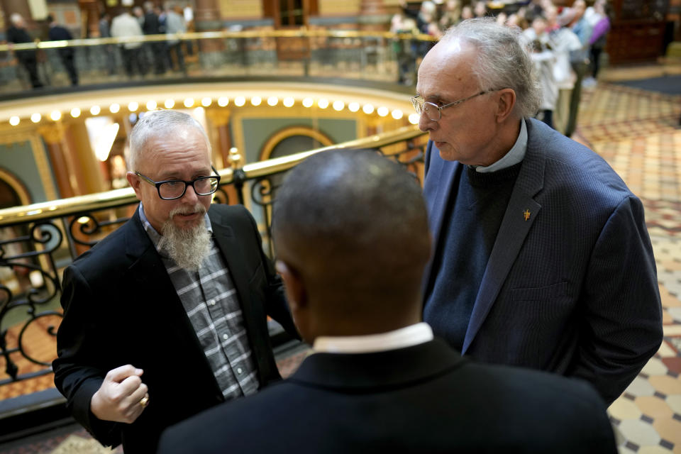 Rev. Mike Demastus, of Des Moines, Iowa, left, and Rev. Bob Curry, of Johnston, Iowa, right, talk with State Rep. Eddie Andrews, center, Thursday, April 6, 2023, at the Statehouse in Des Moines, Iowa. (AP Photo/Charlie Neibergall)