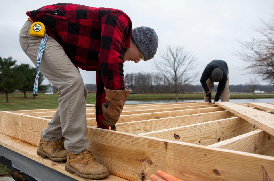 Levi Kline, 17 of Carroll, hammers a nail into the floor of a house he and other Fairfield Career Center students are building house for Habitat for Humanity at the Fairfield Career Center on Nov. 16, 2022 in Carroll, Ohio. The finished construction on the home is expected to be completed in September of 2023.