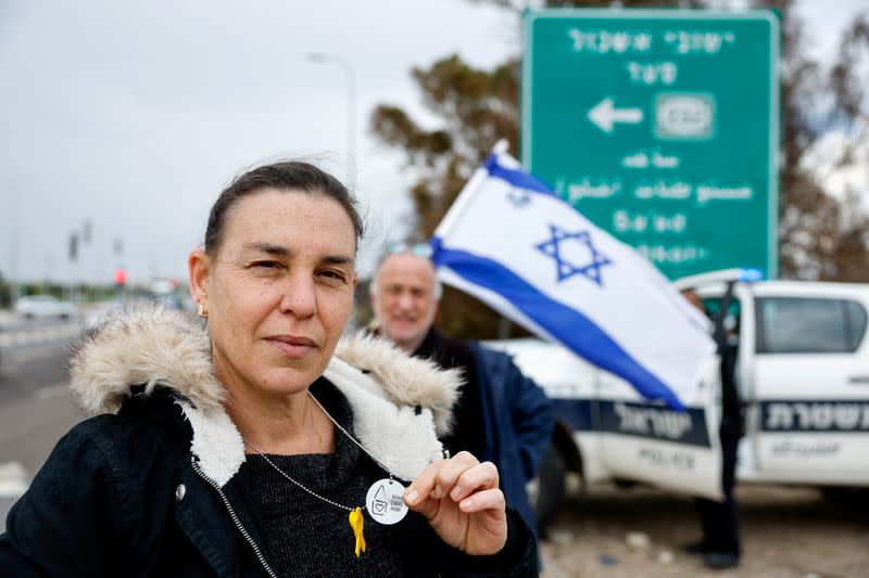 Yael Yolovitch of Kibbutz Nir Oz shows military-style dog tag calling for return of Israeli hostage Omri Miran, near Sderot