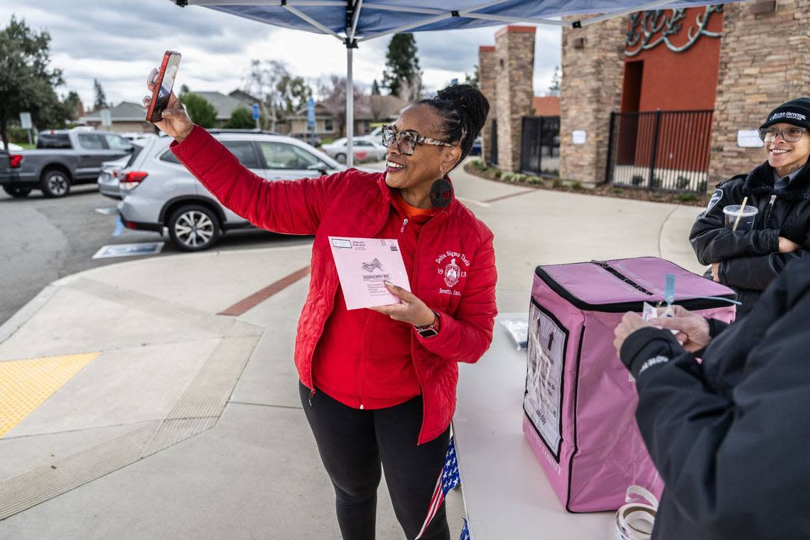 Sandra Patterson takes a selfie at the Robbie Waters Pocket-Greenhaven library on Tuesday to share that she voted with friends. Hector Amezcua/hamezcua@sacbee.com