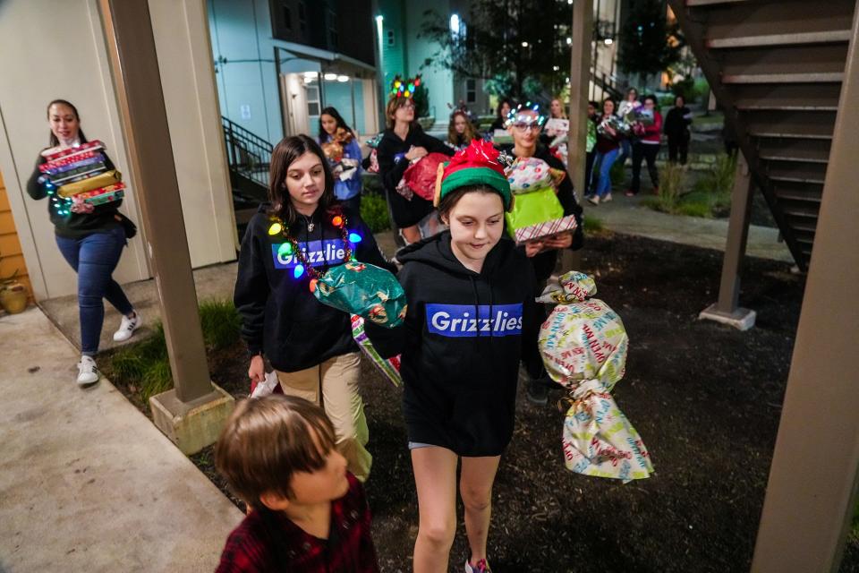 Kaiah Faehnle, 11, helps lead the Grisham Middle School contingent to present the gifts to the Ramirez family at their home in Southwest Austin.