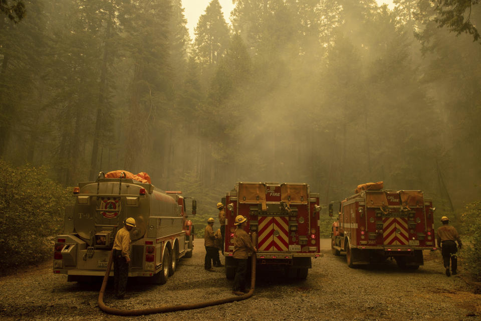 FILE - In this Thursday, Aug. 19, 2021 file photo, firefighters refill water while fighting the Caldor Fire on Hazel Valley Road east of Riverton, Calif. Last week, managers overseeing the fight against the massive wildfire scorching California's Lake Tahoe region thought they could have it contained by the start of this week. Instead, on Monday, Aug. 30, 2021, the Caldor Fire crested the Sierra Nevada, forcing the unprecedented evacuation of all 22,000 residents of South Lake Tahoe. (AP Photo/Ethan Swope, File)