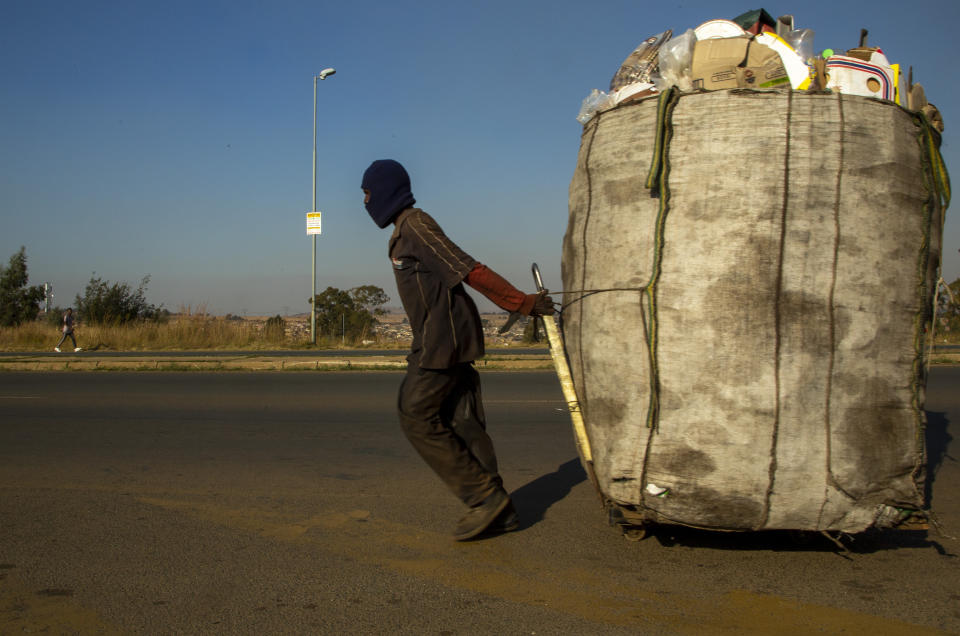 A man pulls a trolley filled with cardboard and plastic bottles for recycling through the streets at Phumlamqashi informal settlement near Johannesburg, South Africa, Wednesday, June 3, 2020. (AP Photo/Themba Hadebe)