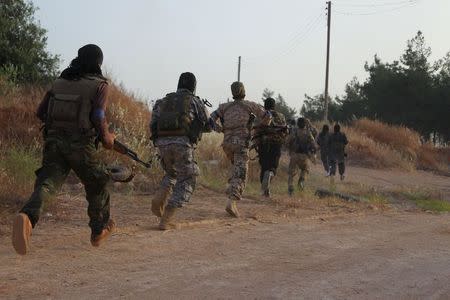 Members of al Qaeda's Nusra Front carry their weapons as they move towards their positions during an offensive to take control of the northwestern city of Ariha from forces loyal to Syria's President Bashar al-Assad, in Idlib province May 28, 2015. REUTERS/Ammar Abdullah