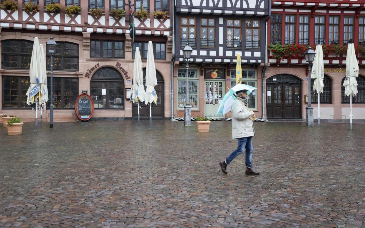 A pedestrian walks along the cobbles of Roemerberg Square in Frankfurt during the national lockdown - Alex Kraus/Bloomberg 