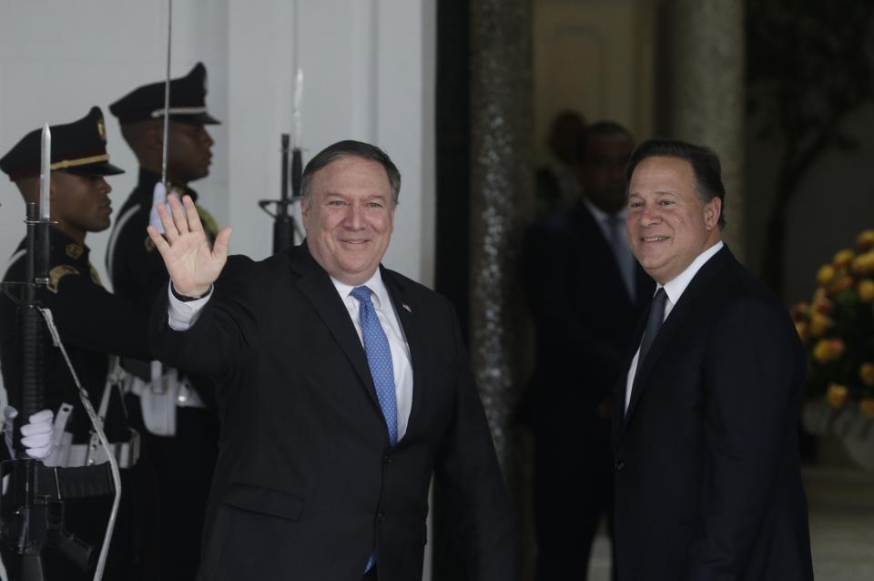 El secretario de Estado estadounidense Mike Pompeo, izquierda, saluda a la prensa mientras el presidente panameño Juan Carlos Varela se detiene junto a él tras llegar al Palacio Presidencial en Ciudad de Panamá el jueves 18 de octubre de 2018. (AP Foto/Arnulfo Franco)