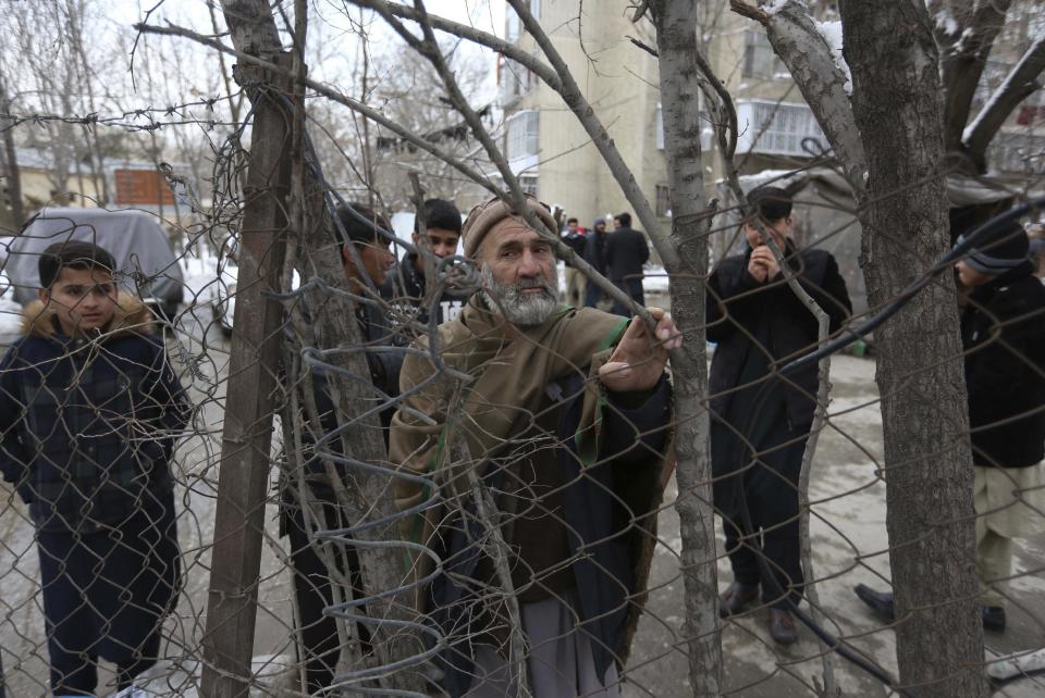 Bystanders watch the aftermath of a suicide attack on the Supreme Court in Kabul, Afghanistan, Tuesday, Feb. 7, 2017. A suicide bomber on Tuesday targeted the Supreme Court building in the Afghan capital, Kabul, killing more than a dozen people, officials said. (AP Photo/Rahmat Gul)