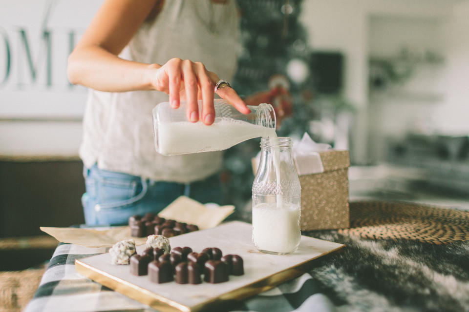 Midsection Of Women Pouring Milk